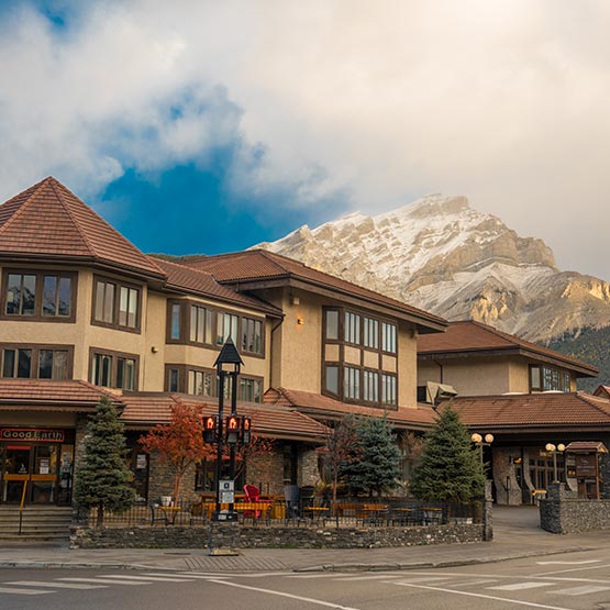 A hotel on a street, with a mountain in the background.