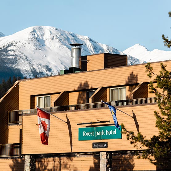 A hotel facade with Canada and Alberta flags.